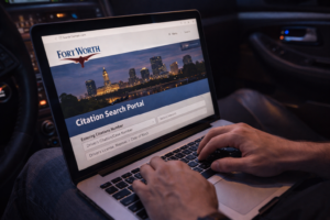 Driver searching traffic citation online on a laptop showing the process related to Austin speeding ticket dismissal and checking ticket details
